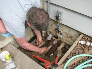 a technician checks the sprinkler line connections box